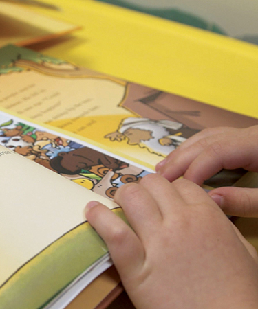 close-up of a small child reading a book