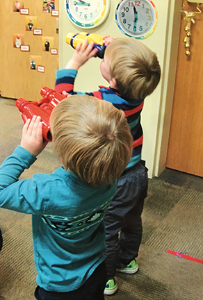 two blonde boys looking through binoculars