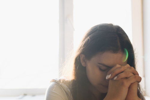 A woman quietly prays by herself.