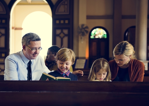 A family sits in a pew at church.