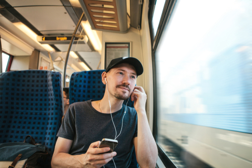 A young man listens to a Lutheran podcast during his train ride.