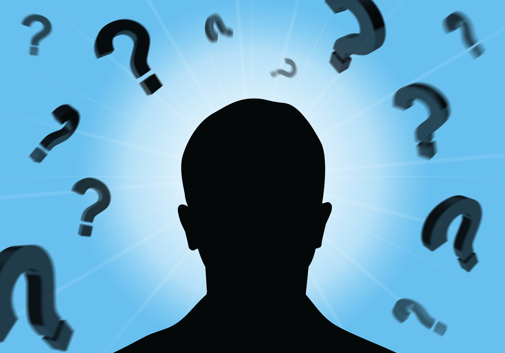Silhouette of a person’s head with question marks floating around it.