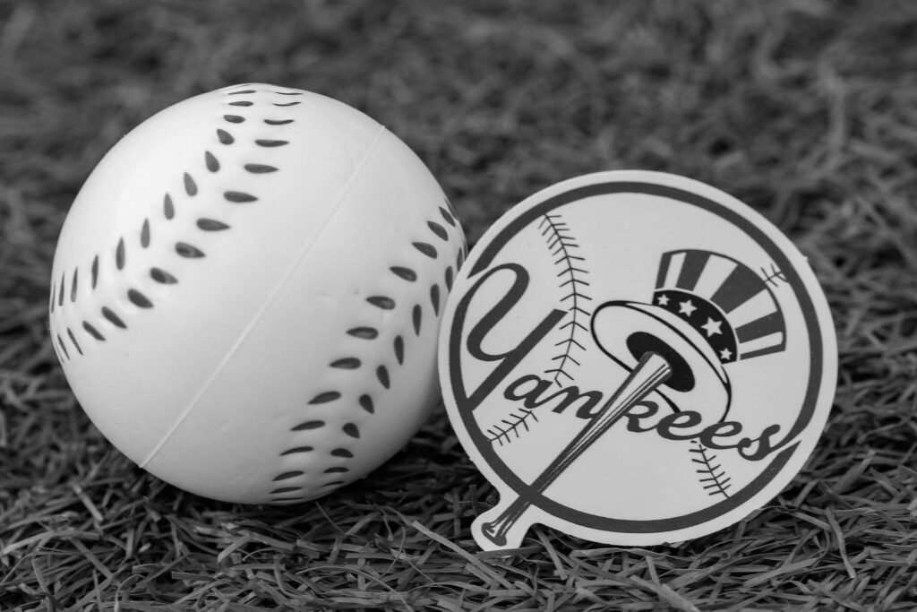 A New York Yankees emblem next to a baseball.
