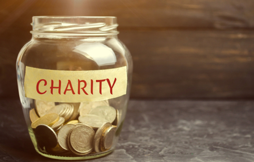 A jar labeled "charity" with coins in it.