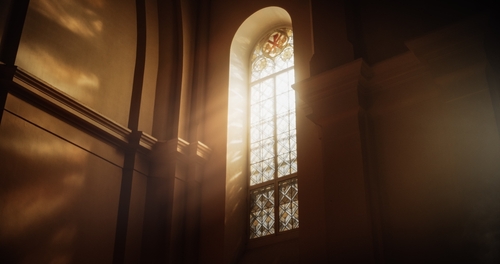 Light floods through an ornate church window.