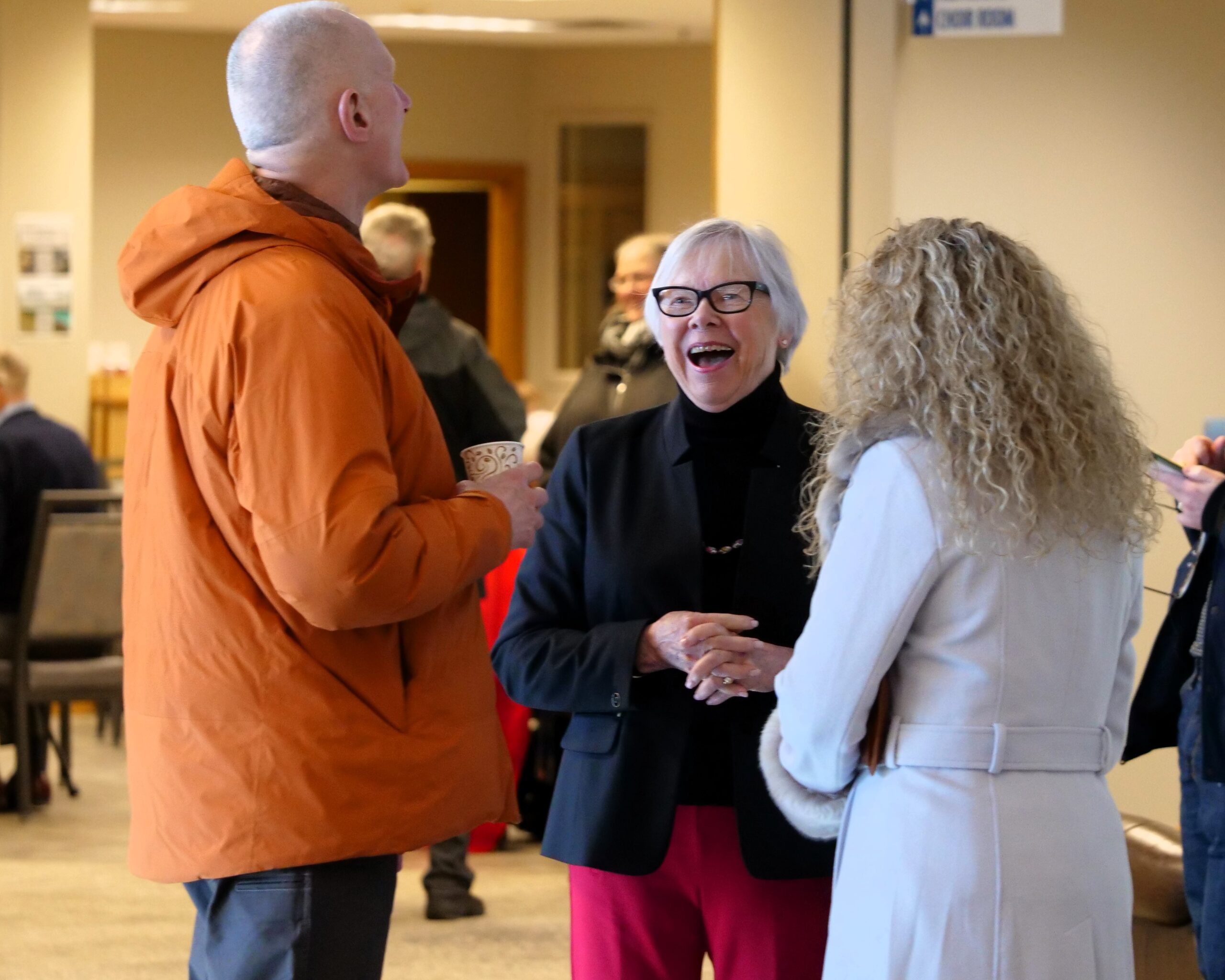 Three people standing and laughing