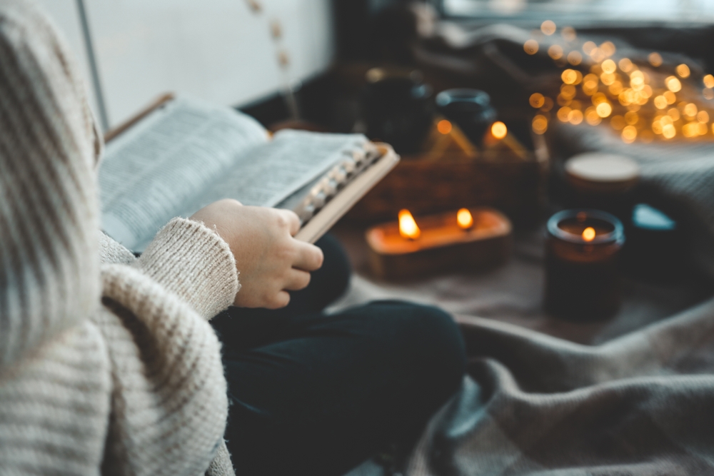 A woman reads the Bible in a cozy environment.