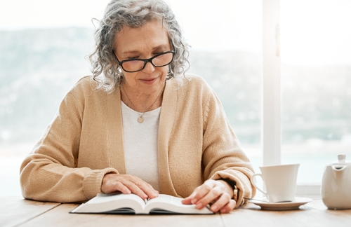 An older woman reads the Bible.