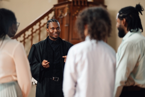 A pastor speaks to a group of people in a church.